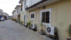 A row of residential buildings with air conditioning units and potted plants. - AES Luxury Apartments (Lagos)