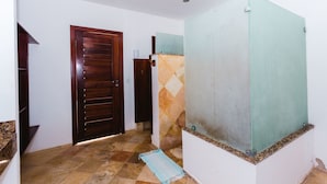 Un pasillo con puerta de madera, separador de vidrio y suelo de baldosas.