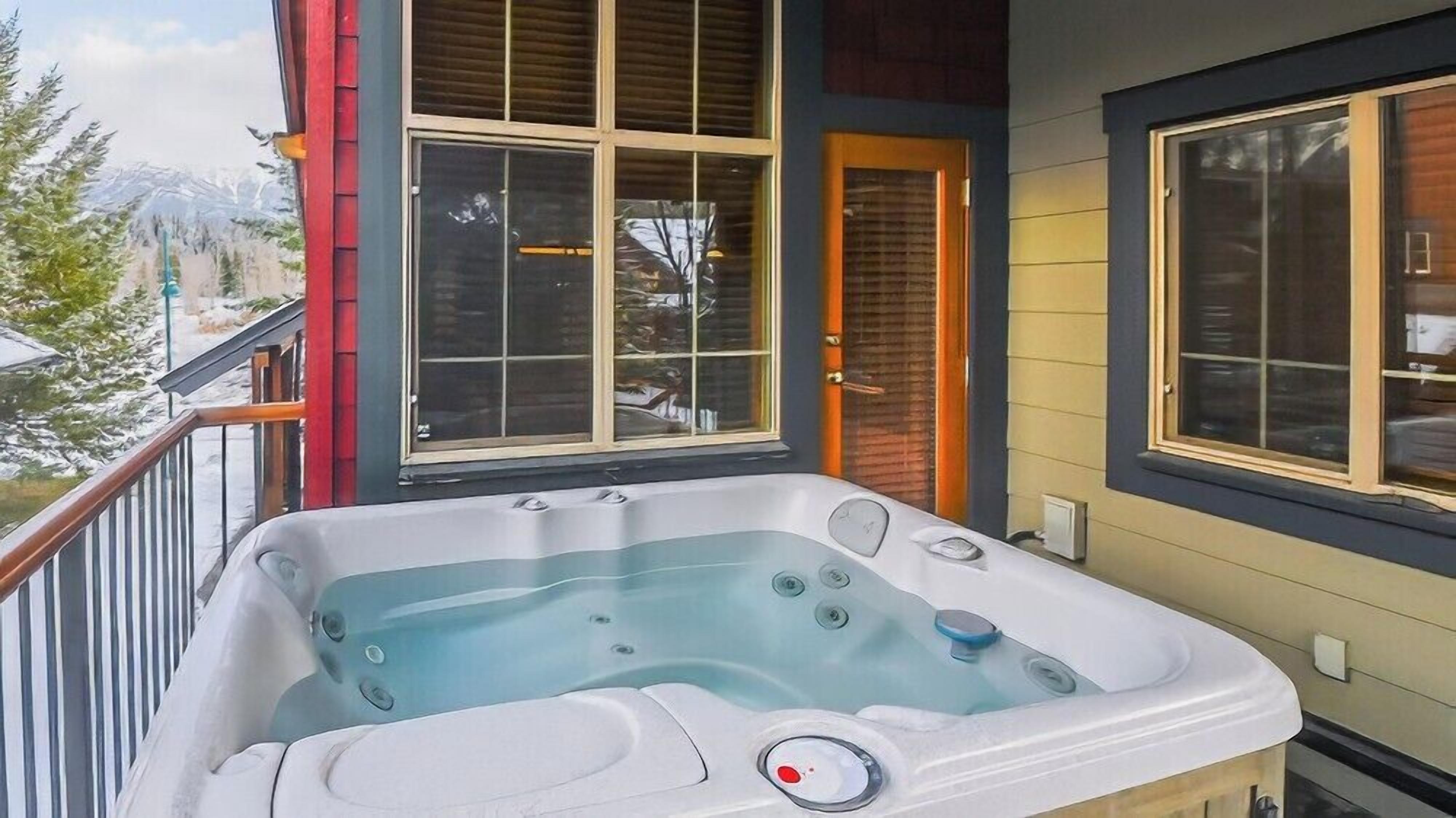 A hot tub on a balcony with a view of a mountain.
