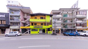 A multi-story hotel with a bright yellow facade and a sign indicating it is the Hotel Villas de San Juan. - Ayenda Villas de San Juan (Medellín)