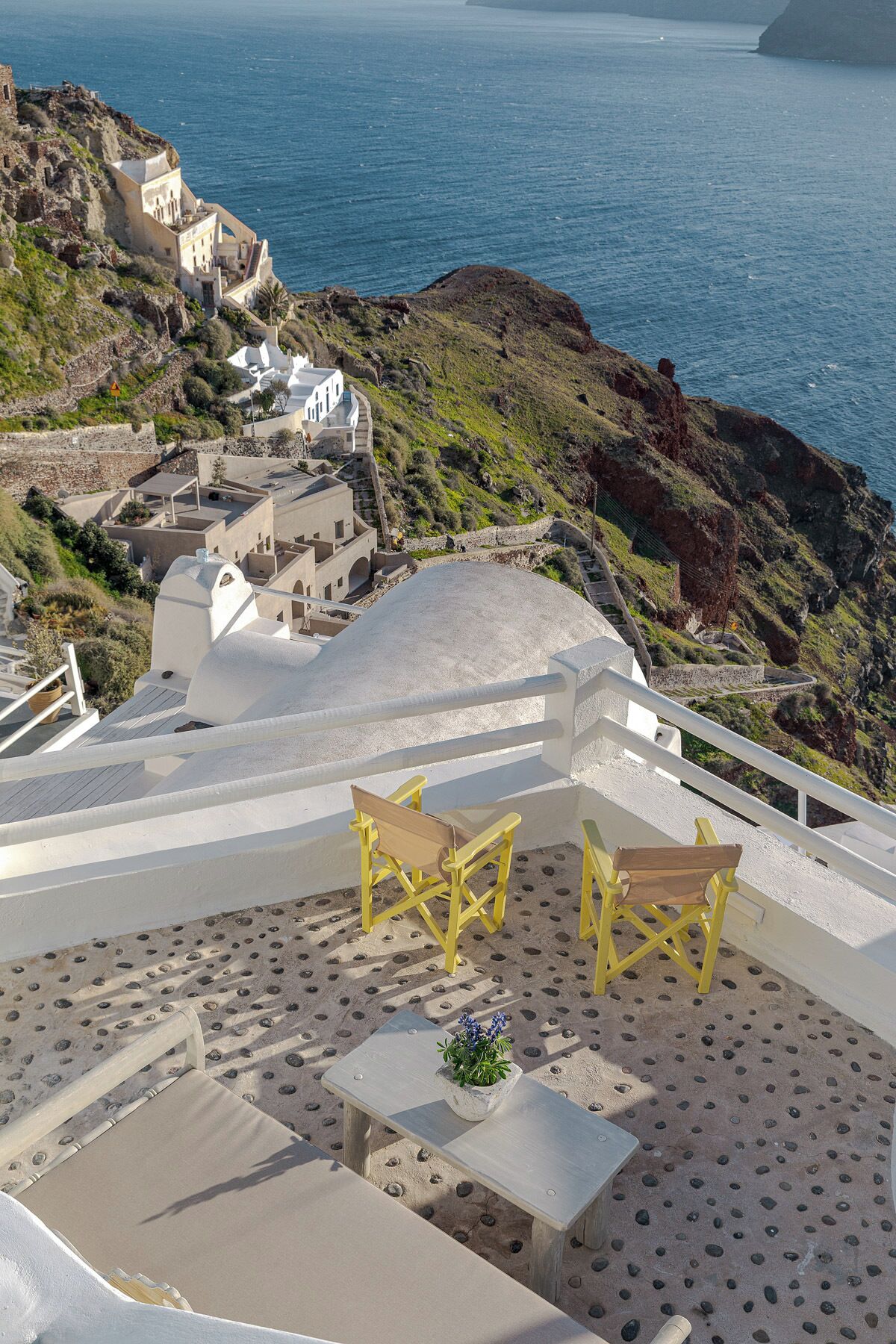 A coastal terrace with outdoor seating and a view of the sea.