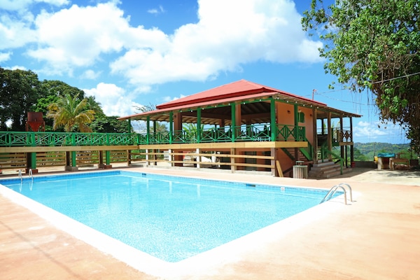 Una piscina al aire libre, sillones reclinables de piscina