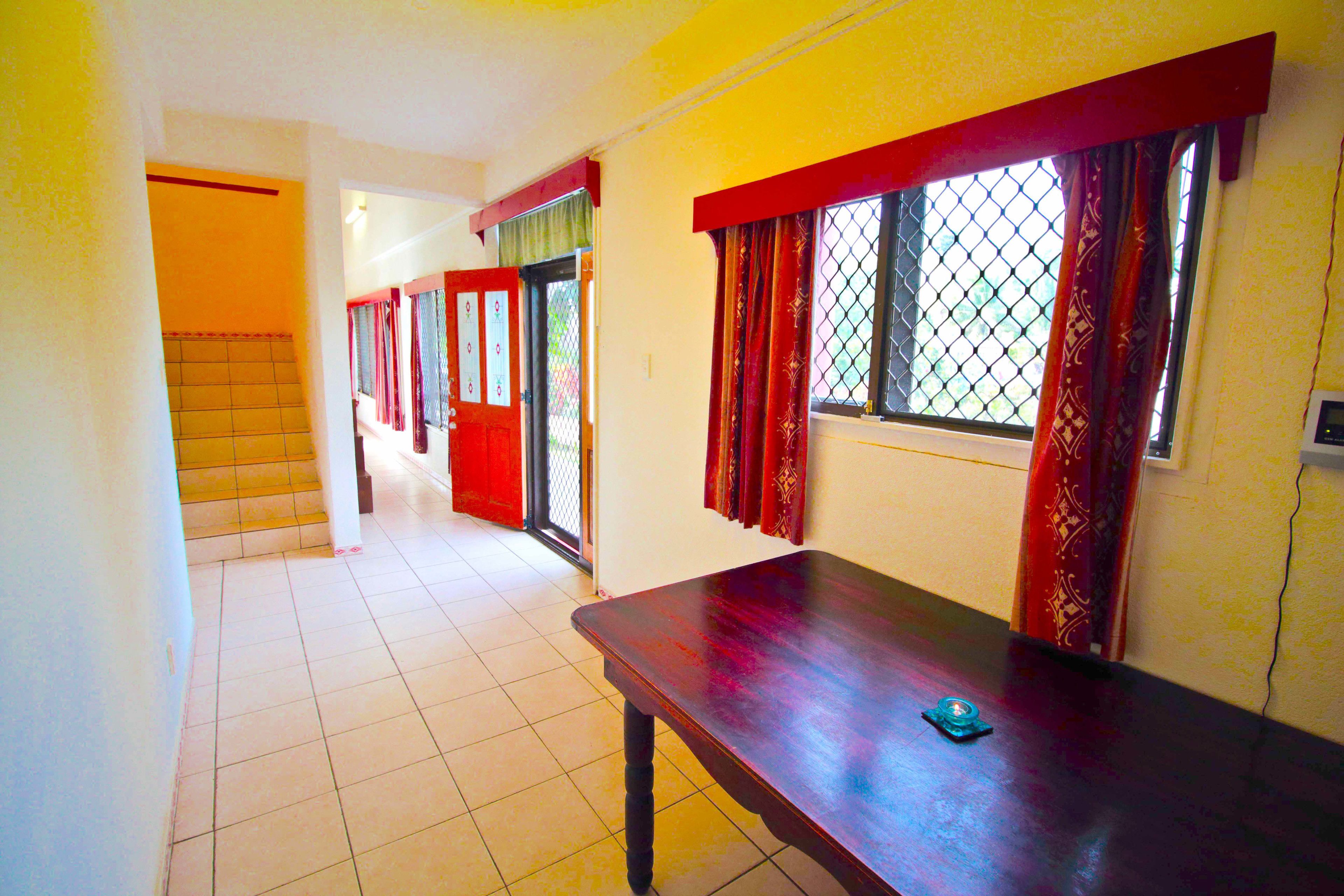 A corridor with a wooden bench, tiled floor, and a door leading to another room.