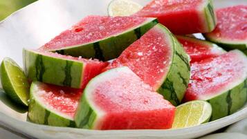 A bowl of watermelon slices and lime wedges.