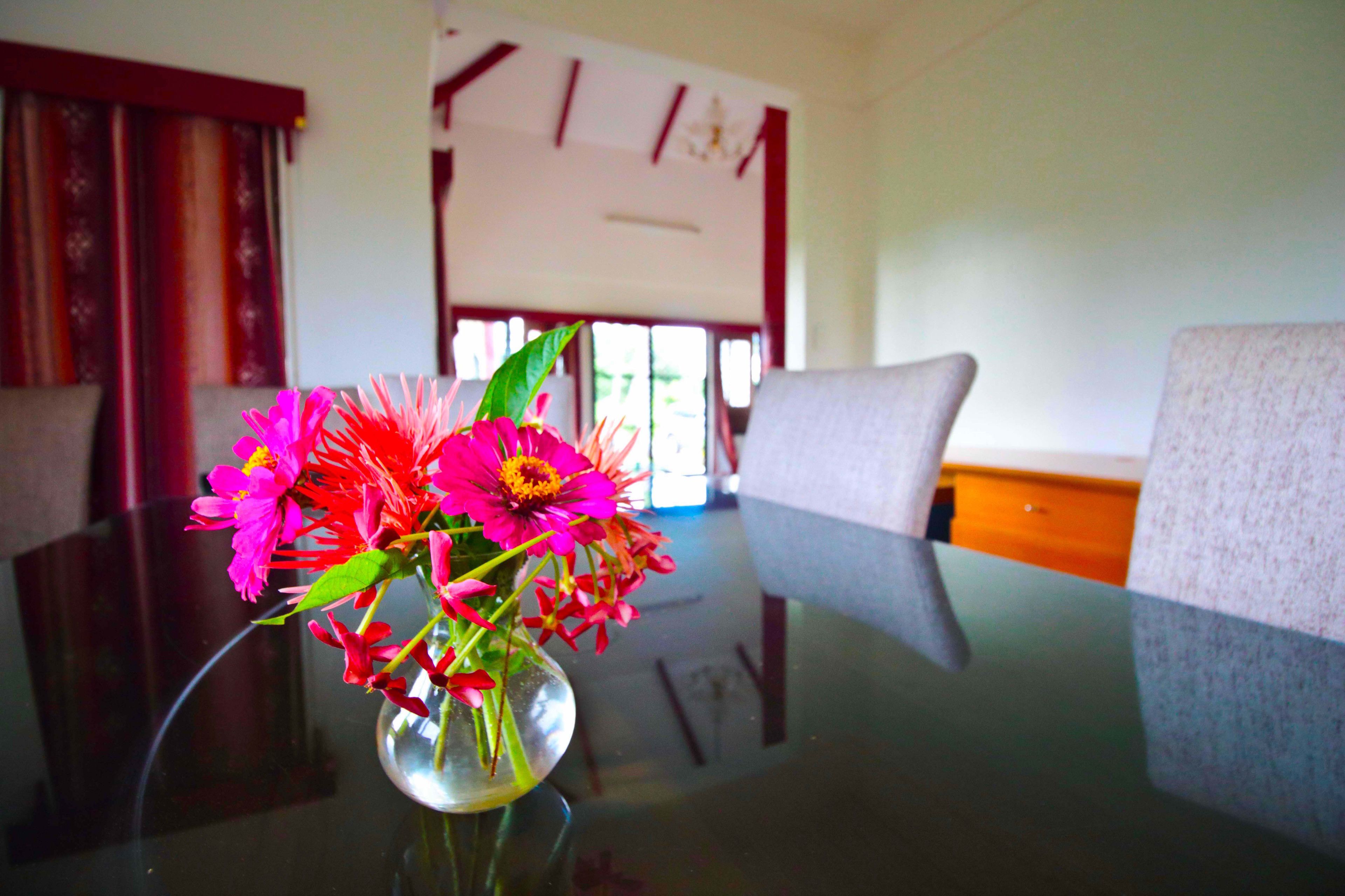 A dining table with a vase of flowers.