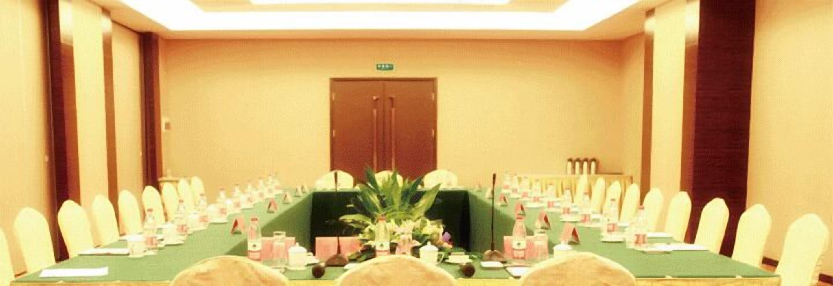 A conference room with a long table, chairs, and a door in the background.