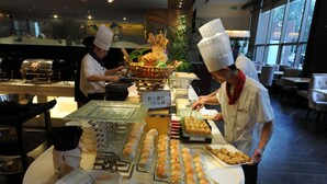 Un buffet proposant une variété de plats et un chef qui prépare les aliments.