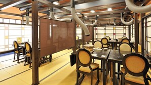 Una habitación tradicional japonesa con suelo de tatami, muebles de madera y una pantalla grande.