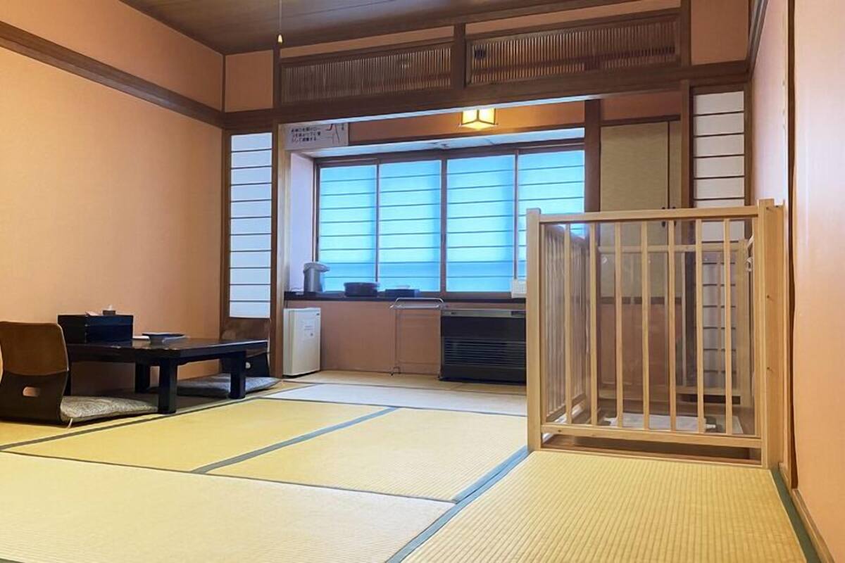 Ein traditioneller japanischer Raum mit Tatami-Bodenbelag, einem niedrigen Tisch und einer Schiebetür.