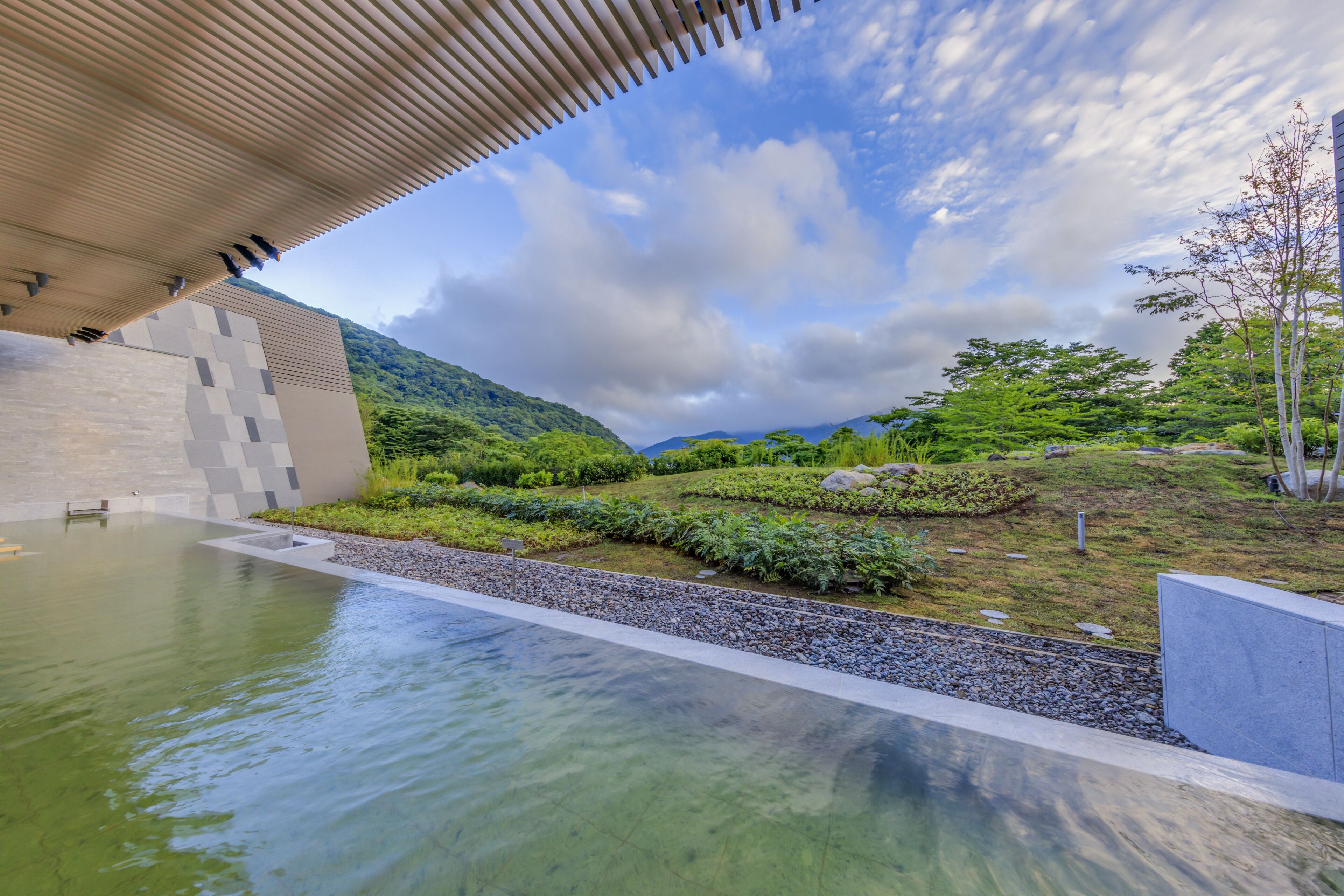 Un bâtiment moderne doté d’une piscine et offrant une vue sur un paysage verdoyant et luxuriant.