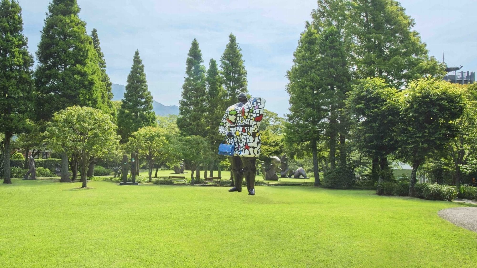 A statue in a park with green grass and trees.