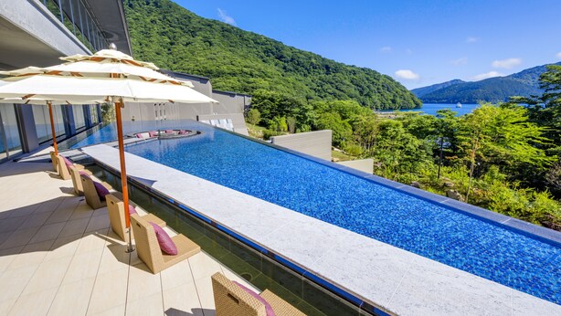 A modern hotel with a rooftop infinity pool overlooking a mountainous landscape and a body of water. - Hakone Ashinoko Hanaori（ORIX HOTELS & RESORTS） (Hakone)