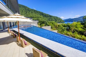 A modern hotel with a rooftop infinity pool overlooking a mountainous landscape and a body of water. - Hakone Ashinoko Hanaori（ORIX HOTELS & RESORTS） (Hakone)