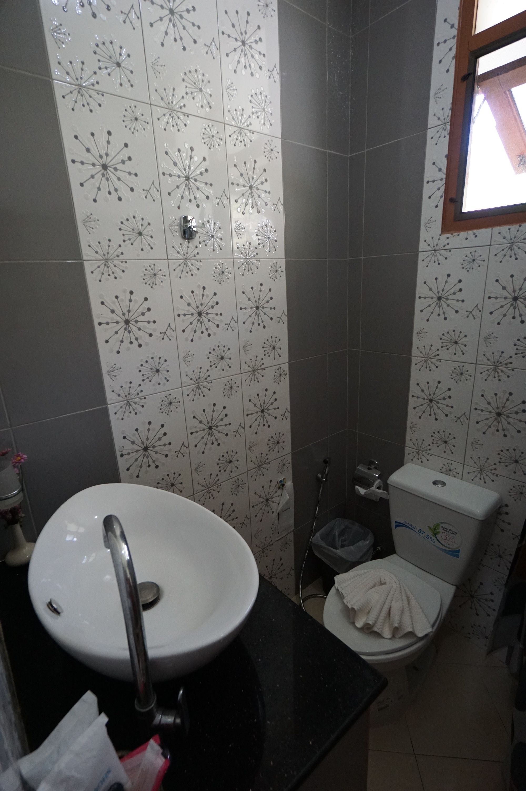 A bathroom with a white sink, a toilet, and a shower area.