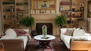 A traditional living room with two sofas, a round coffee table, and a fireplace. - The Denny House (Paint Lick)