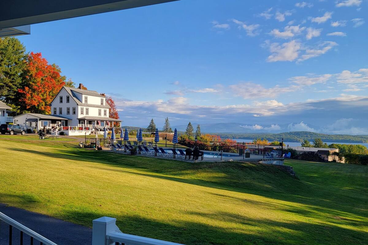 A hotel with a pool area, outdoor seating, and a view of the lake.