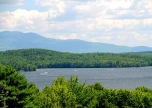 A lake surrounded by dense forest and mountains in the background.