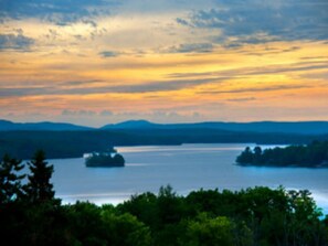 A lake with a forested shoreline and distant mountains.