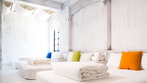 Una habitación de hotel moderna con una cama grande, una cama más pequeña y un espacio para sentarse.
