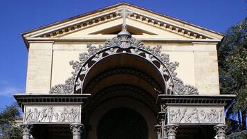 A classical building with an ornate entrance featuring columns and detailed sculptures.