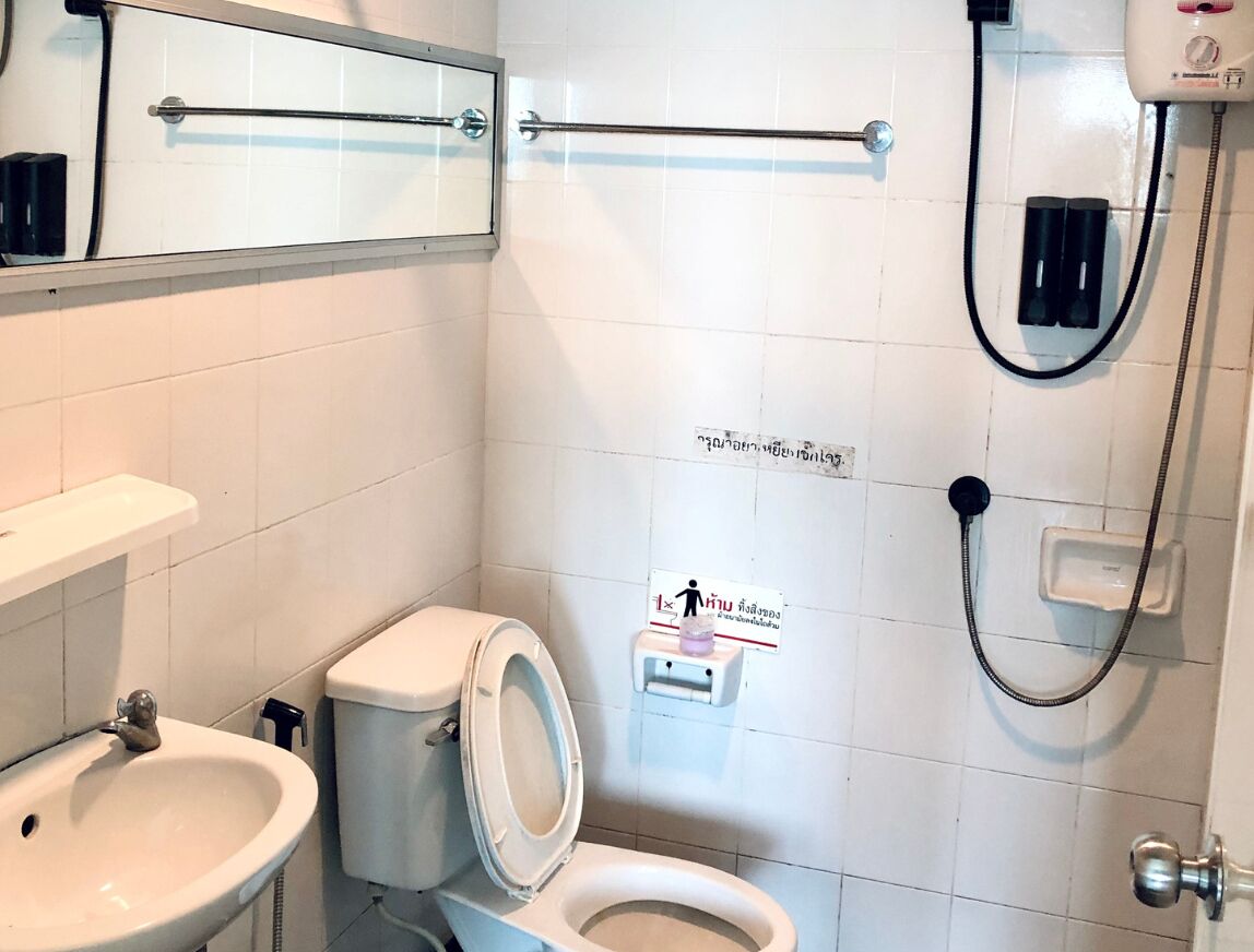 A bathroom with a toilet, sink, and a hand dryer.