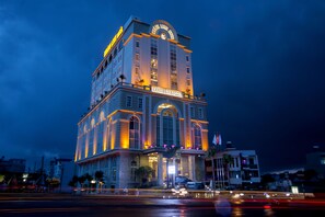 A multi-story hotel with a prominent entrance and a clock tower. - Khánh Linh Hotel (Pleiku)