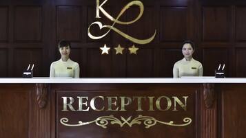 A reception desk with a sign that reads "RECEPTION" and a decorative "K" with stars above it.