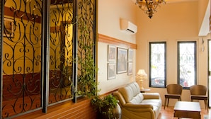 A spacious living room with a sofa, chairs, a coffee table, and a decorative iron partition. - MyDream Homestay (Ipoh)