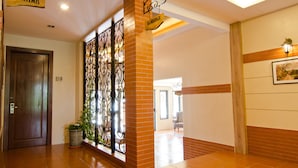 A hotel lobby with a wooden door labeled "119", a decorative metal gate, and a sign reading "BAMBURGH". - MyDream Homestay (Ipoh)