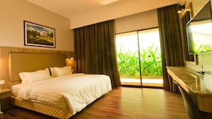 A hotel room with a bed, a nightstand, a bathroom with a mirror, and a view of greenery through the window. - MyDream Homestay (Ipoh)