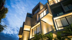 Un immeuble moderne à plusieurs étages, doté d’une façade géométrique et de grandes fenêtres.