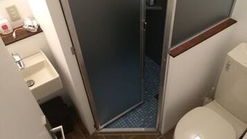 Un baño pequeño con inodoro, lavabo y ducha.