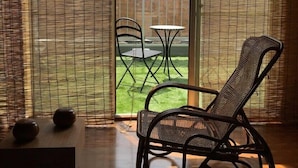 A room with a sliding glass door leading to a patio with a table and chairs. - Uno Port INN (Tamano)