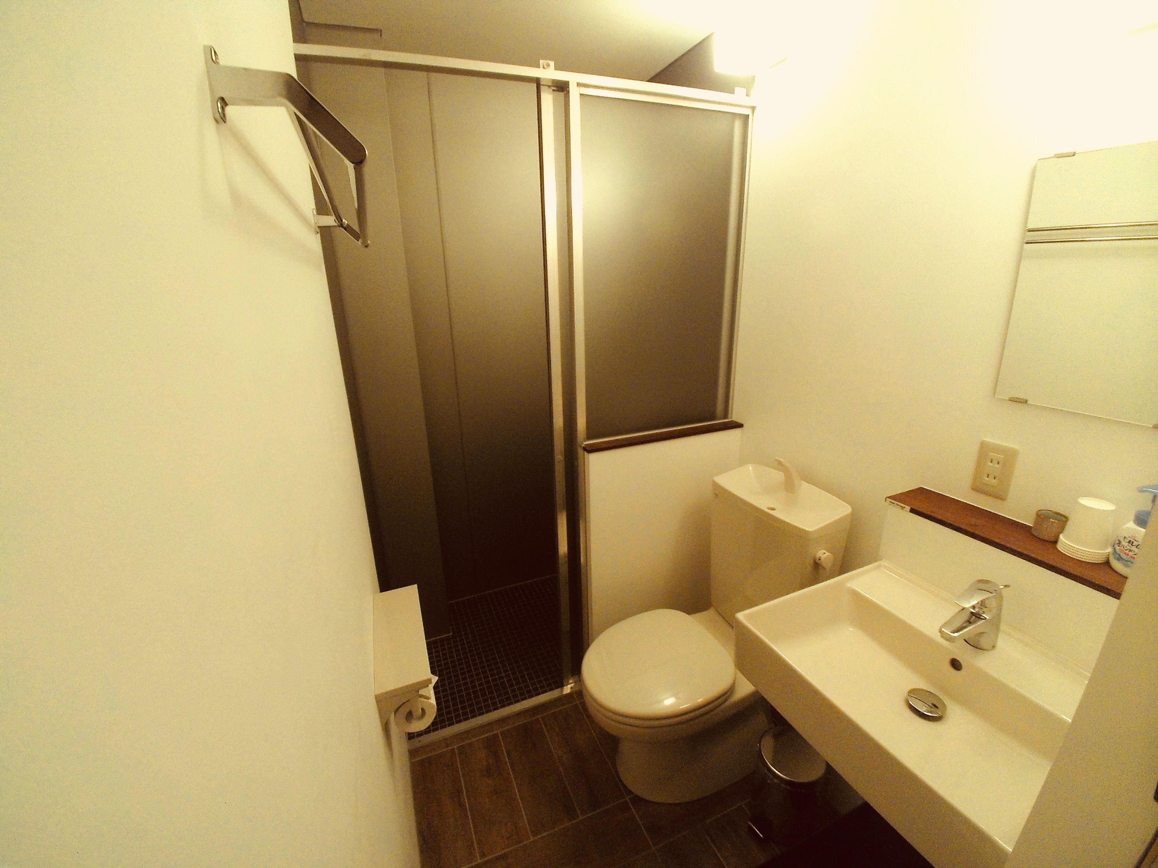 A bathroom with a toilet, sink, and shower.