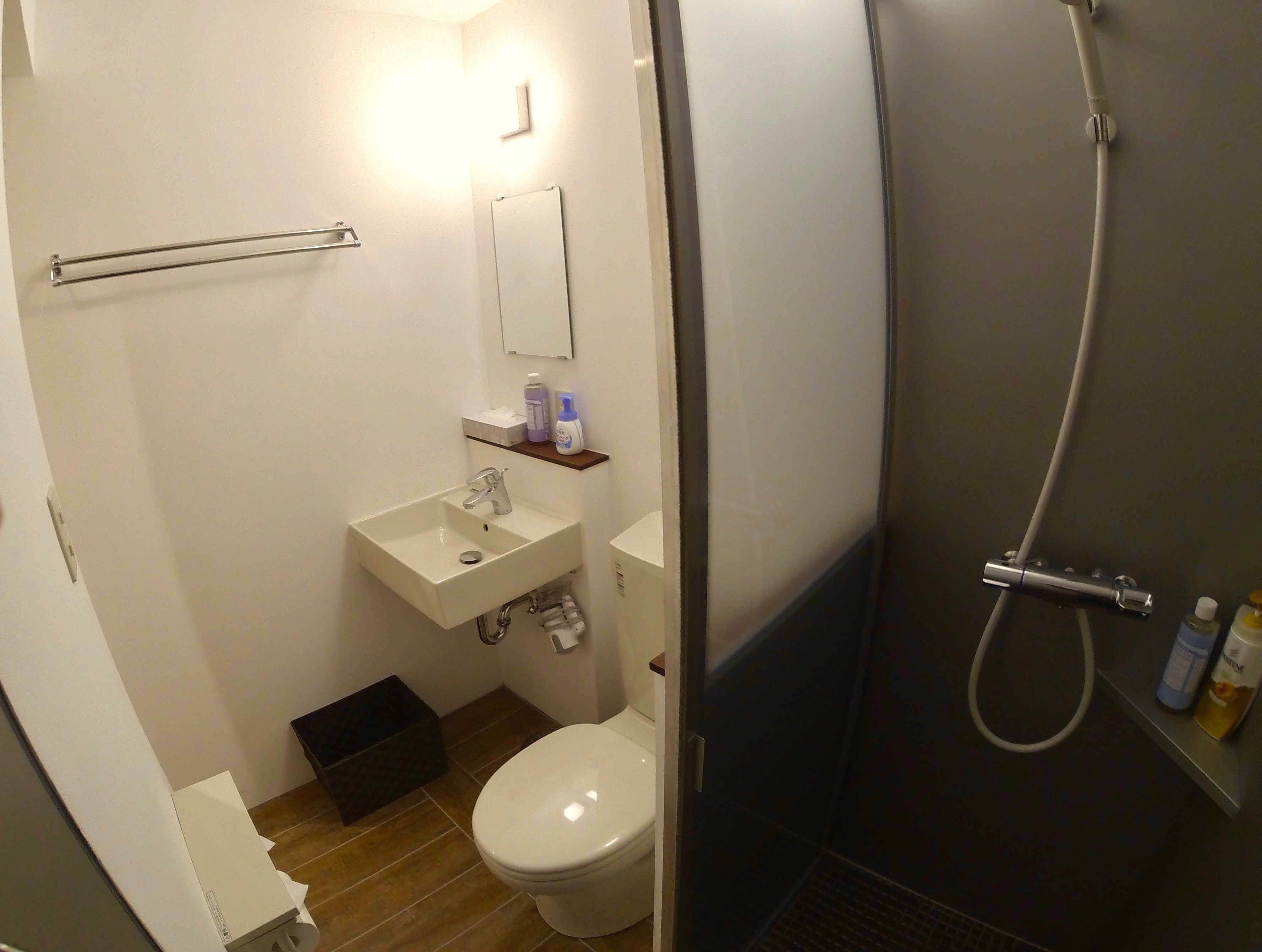 Een badkamer met toilet, wastafel en douche.