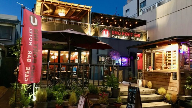 A cafe with outdoor seating, a wooden facade, and a sign advertising a port inn. - Uno Port INN (Tamano)
