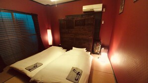 A hotel room with a bed, a nightstand, a lamp, and a window with blinds. - Uno Port INN (Tamano)