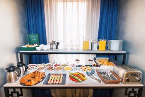Una mesa de buffet con diferentes alimentos, un tostador y una cafetera.