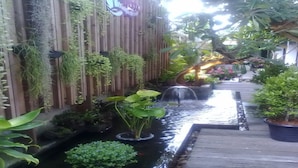 A narrow water feature with plants and a wooden deck. - La Playa Boutique Resort (Chonburi)