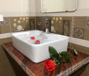 A bathroom with a white sink, a faucet, and a decorative tile backsplash. - Sapa Odyssey Hostel (Sa Pa)