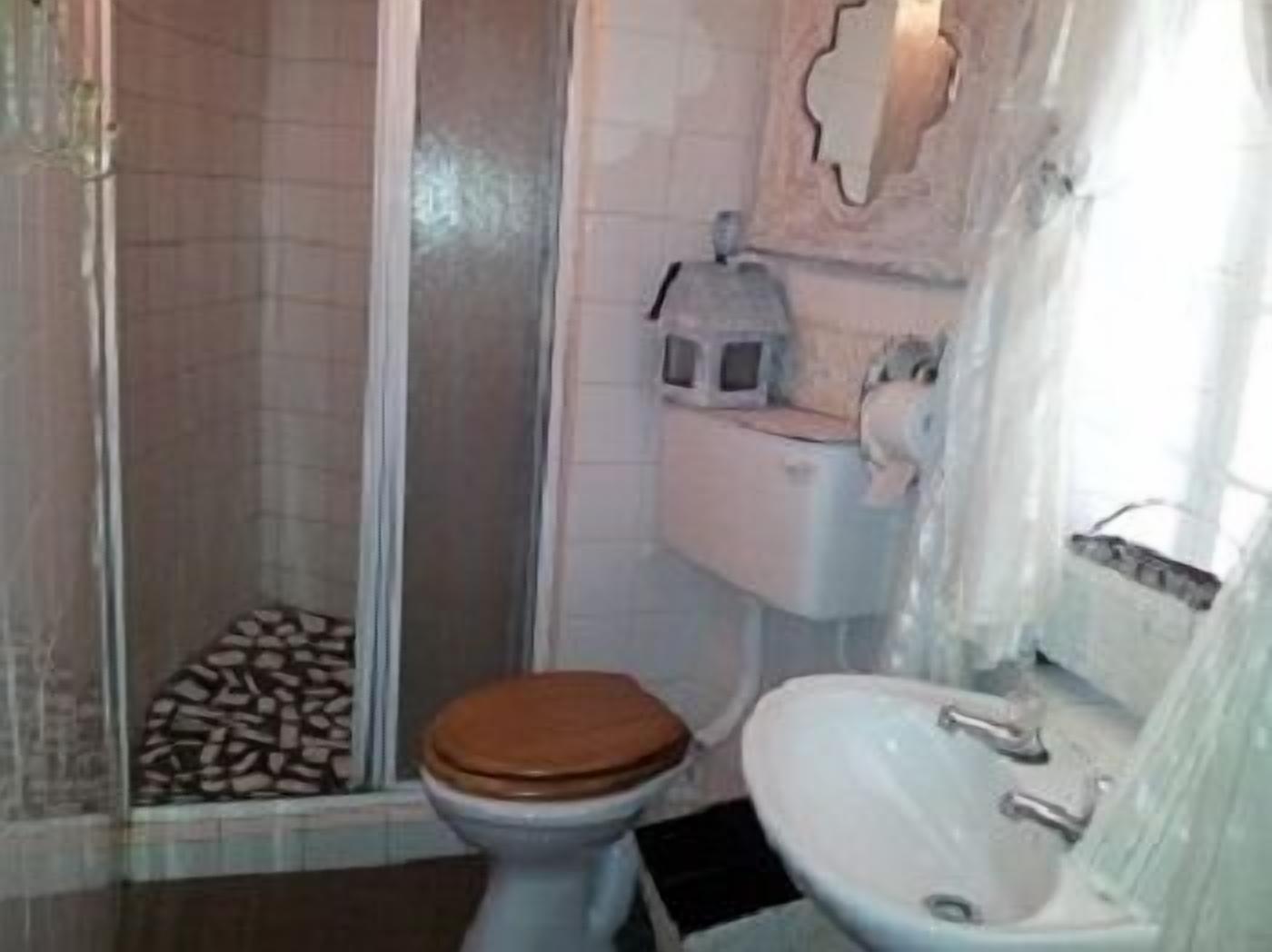 Un baño con ducha, inodoro y lavabo.