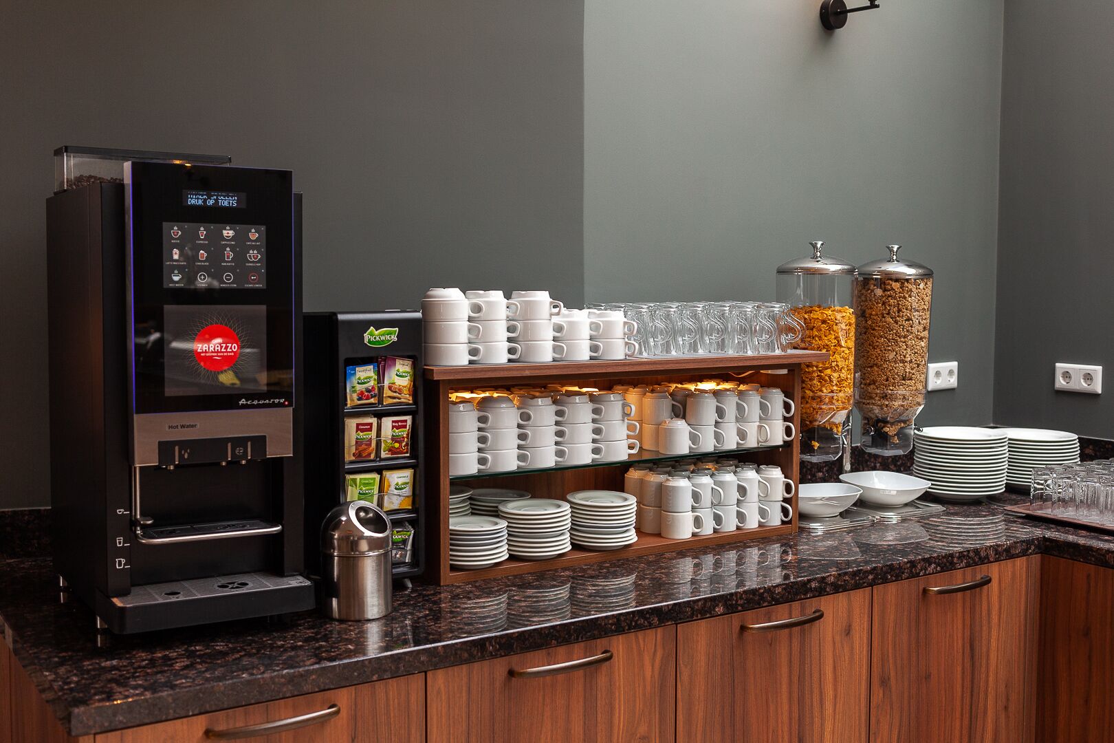 A coffee station with a coffee machine, a beverage dispenser, and a snack bar.