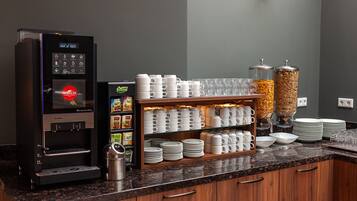 A coffee station with a coffee machine, a beverage dispenser, and a snack bar.