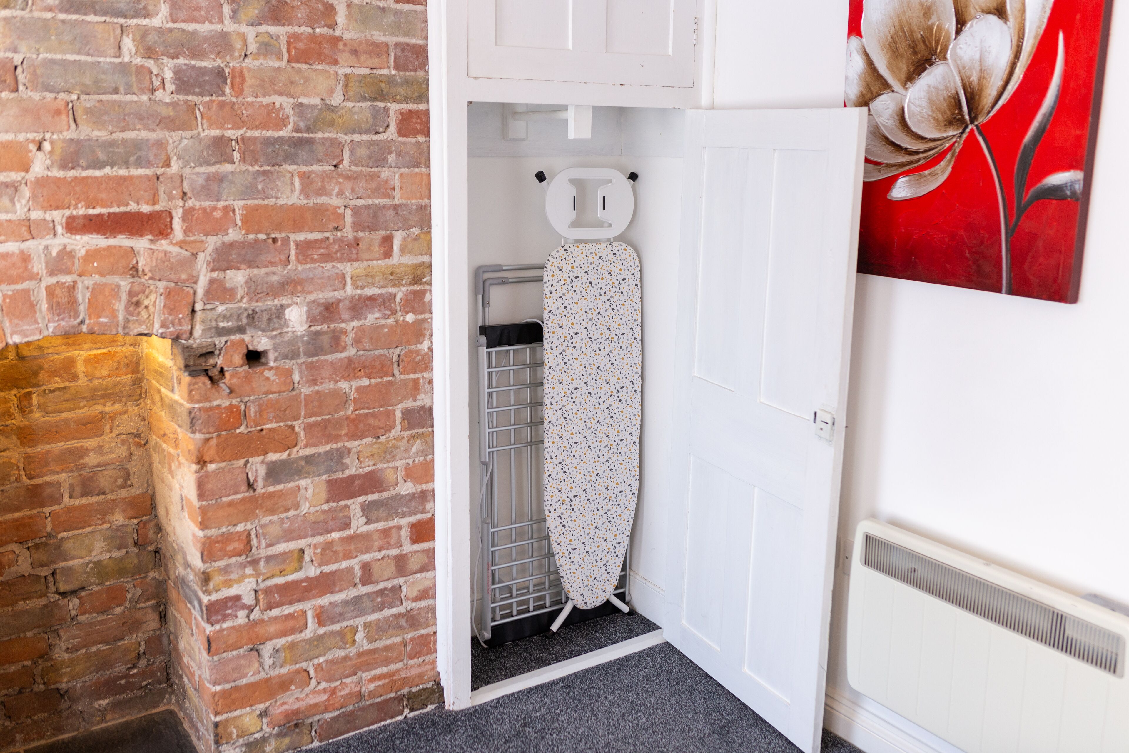 A corner of a room with a brick wall, a white door, and a radiator.