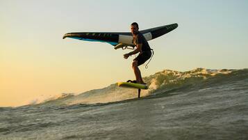 A person surfing on a wave with a surfboard that has "UNIT 45" written on it.