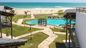 Un resort con piscina, playa y vista despejada al océano.