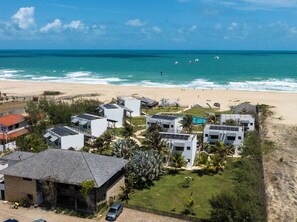 Une station balnéaire comprenant plusieurs bâtiments, une plage et offrant une vue sur l’océan.