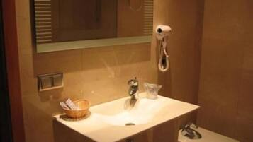 Un baño con lavamanos, espejo y retrete.