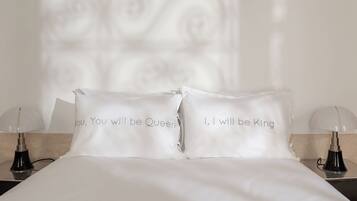 A neatly made bed with two pillows, each with a printed message.