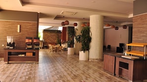 A modern lobby with a reception desk, seating area, and large potted plants. - Vega Green Apart Hotel (Alanya)